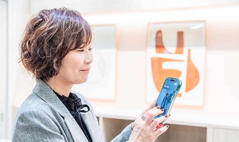 ストアインフルエンサーがスマホでコーディネート写真を編集している様子